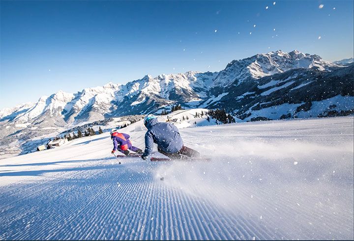 Zwei Skifahrer flitzen über die gepflegte Piste in Maria Alm